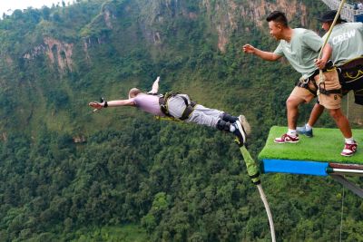 Bungee jumper diving off the Kushma bungee jump platform above the Kali Gandaki Gorge, Nepal